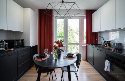 a kitchen with a table with a vase of flowers at FLATMORE Apartament Długa 8m6 in Zielona Góra
