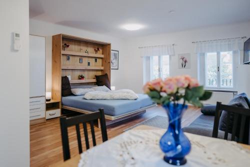 Una sala de estar con un jarrón de flores sobre una mesa. en Schloss-Appartements, en Eisenstadt