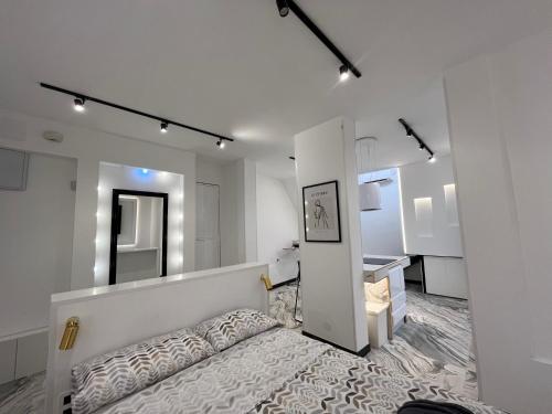 biały pokój z łóżkiem i lustrem w obiekcie BS4 suite Luxury Madrid centro w Madrycie