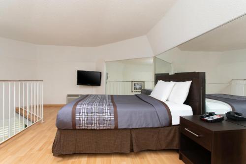 a hotel room with a bed and a television at Super 5 Inn in Mississauga