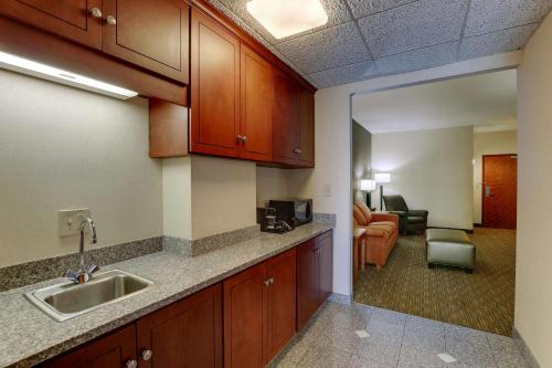 a kitchen with a sink and a living room at Drury Inn & Suites Montgomery in Montgomery
