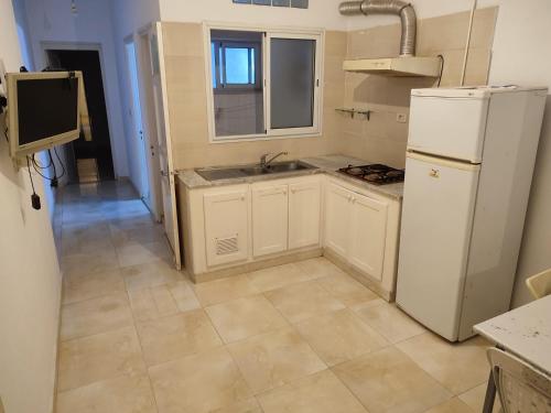 a kitchen with a white refrigerator and a sink at Calm place and near to the beach in Monastir