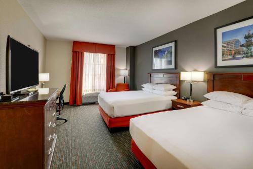 Drury Inn & Suites Montgomery في مونتغومري: غرفة فندقية بسريرين وتلفزيون بشاشة مسطحة
