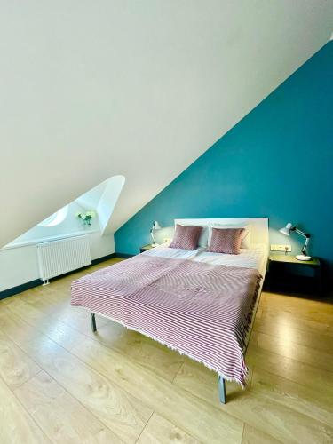 ein Schlafzimmer mit einem großen Bett mit blauer Wand in der Unterkunft SKY Apartments in Kaunas