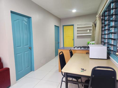 a kitchen with a table and a blue door at Home Away from Home in Suva