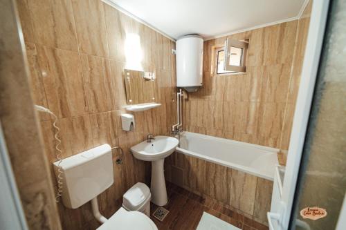 a bathroom with a toilet and a sink and a tub at Casa Badea in Murighiol