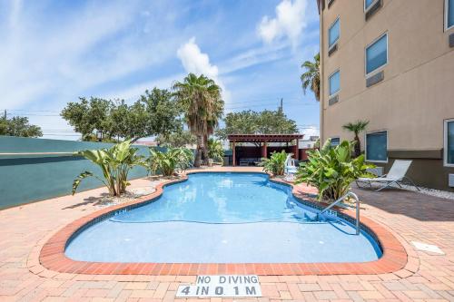 a swimming pool in front of a building at Holiday Inn - Brownsville, an IHG Hotel in Brownsville