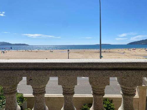 a view of the beach from the balcony of a building at PLAYA AMERICA MAR in Nigrán