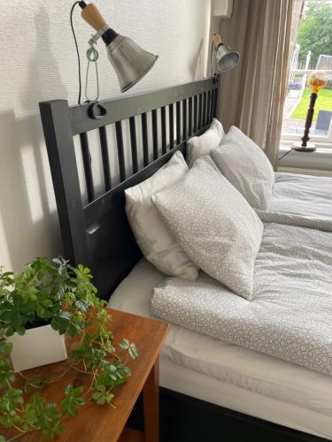 1 dormitorio con 1 cama con lámpara y mesa en Gårdshus - best location in the center of Gränna, en Gränna