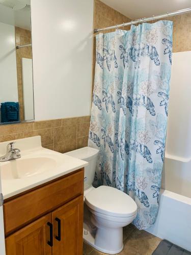 a bathroom with a toilet and a sink and a shower curtain at Blue Diamond Apt 26th St Unit 2 in Ocean City