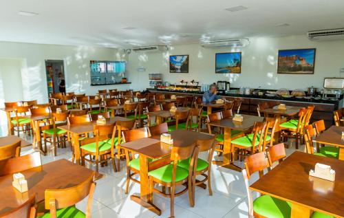 a dining room with wooden tables and chairs at RILL HOTEL BY UCHÔA in Teresina