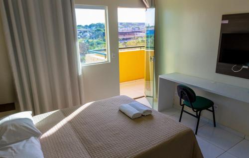 um quarto com uma cama, uma secretária e uma janela em RILL HOTEL BY UCHÔA em Teresina