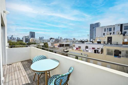 a balcony with a table and chairs and a view of the city at Charming 1BR Apt in Authentic Bauhaus Building in Tel Aviv
