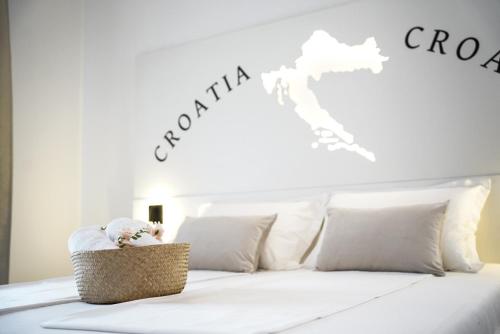 a bed with white sheets and a basket with a teddy bear at Villa Istra Relax Diamond in Rebići