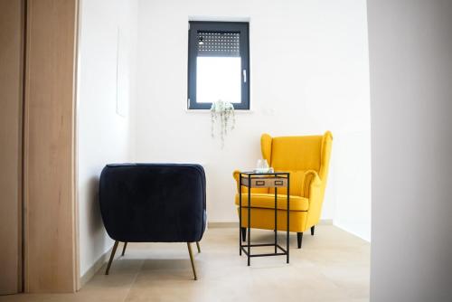 two chairs and a yellow chair in a room at Villa Istra Relax Diamond in Rebići
