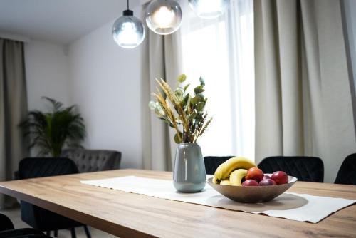 a wooden table with a bowl of fruit and a vase of flowers at Villa Istra Relax Diamond in Rebići