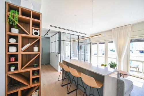 a kitchen with a long counter and chairs in a room at Charming 1BR Apt in Authentic Bauhaus Building in Tel Aviv