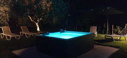 a hot tub in a yard at night with chairs at Carmen de Nella Eco Lodge 4* in Caprino Veronese