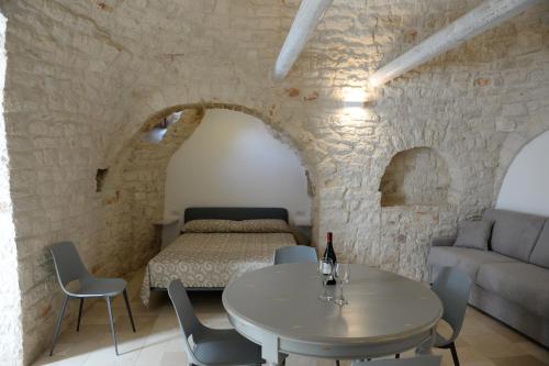 een woonkamer met een tafel en een bed bij Trullo Vino & Amore in Alberobello