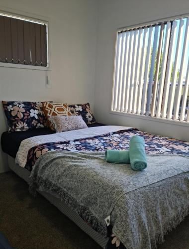 a bedroom with two beds and a large window at Auckland airport holiday home in Auckland
