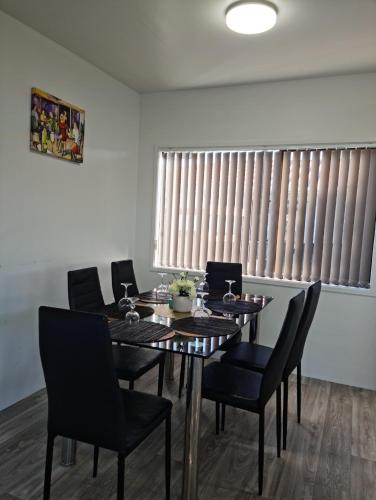 a dining room with a table and chairs and a window at Auckland airport holiday home in Auckland