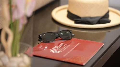 a pair of sunglasses sitting on a table next to a hat at El Olivar Palace Marrakech All Inclusive, Aquapark & SPA in Marrakech