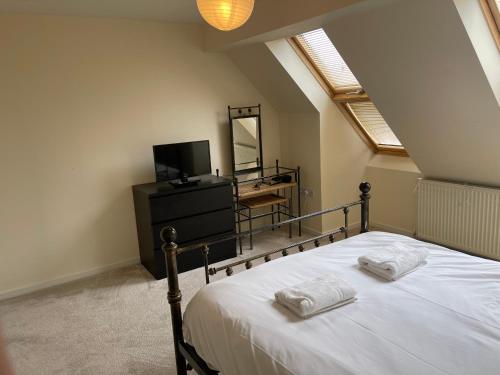 a bedroom with a bed with two towels on it at Family home close to Shrewsbury Town centre in Shrewsbury