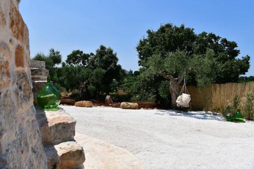 two green glass vases sitting on a stone wall at Trulli di Titti - Luxury Country House in Castellana Grotte