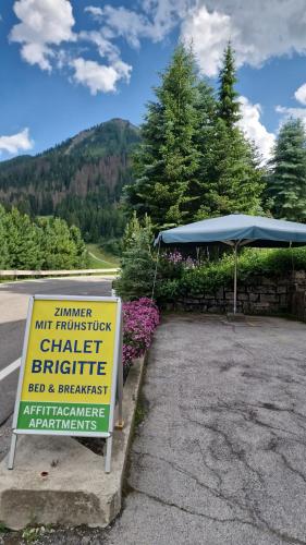 a sign in front of a building with a tent at B&B Chalet Brigitte Hike & Bike in Arabba