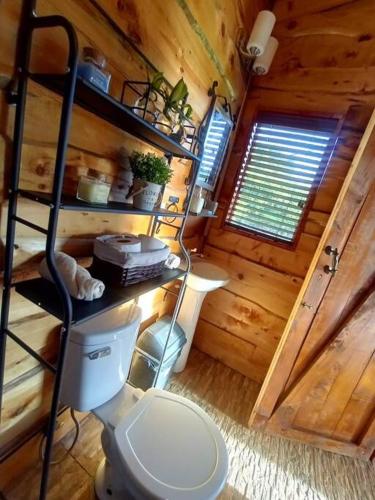 a bathroom with a toilet in a wooden cabin at Finca La Gozadera in Jardín