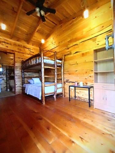 a bedroom with a bed in a log cabin at Finca La Gozadera in Jardín