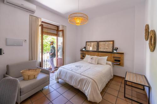 1 dormitorio con 1 cama y 1 silla en Casa el Aguardentero en Alcalá la Real