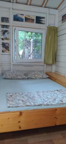 Ce lit se trouve dans un dortoir doté d'une fenêtre. dans l'établissement Kucica Claus, à Ulcinj