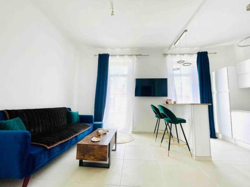 ein Wohnzimmer mit einem blauen Sofa und einem Tisch in der Unterkunft Le Malezi au du village des Pennes Mirabeau in Les-Pennes-Mirabeau