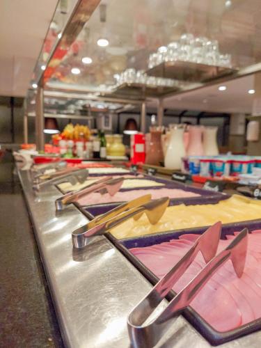 a row of tongs on a buffet line at Mercure Curitiba Batel in Curitiba