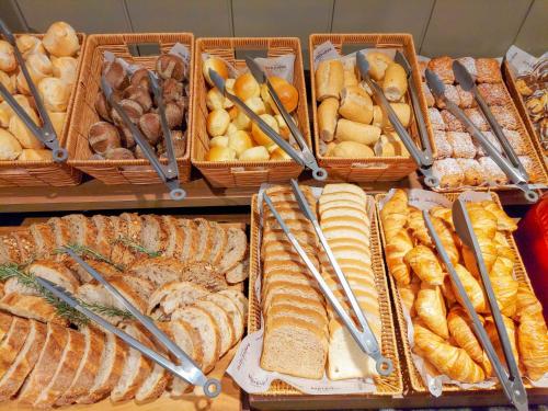 a display of different types of bread and pastries at Mercure Curitiba Batel in Curitiba