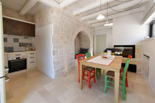 a kitchen and dining room with a table and chairs at Trulli di Titti - Luxury Country House in Castellana Grotte