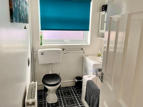 a small bathroom with a toilet and a window at Seaside sanctuary in Pakefield