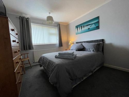 a bedroom with a bed with towels on it at Seaside sanctuary in Pakefield