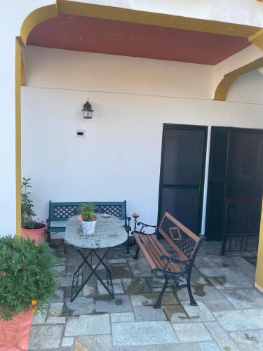 a patio with a table and a bench on a patio at ANASTASIAS HOUSE in Ayios Nikolaos Sithonia