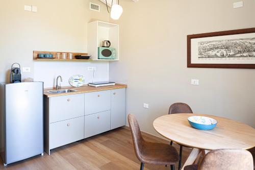 a kitchen with a table and a refrigerator and a table and chairs at La Casa dei Glicini in Levanto