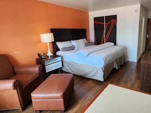 a bedroom with two beds and a chair and a couch at B&J HOTEL AND APARTMENTS in Pecos