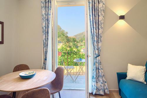 a living room with a table and a glass door at La Casa dei Glicini in Levanto
