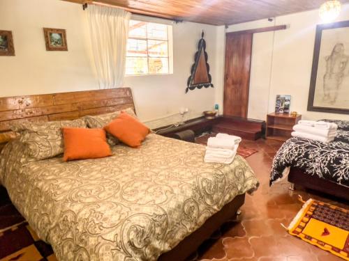 a bedroom with a bed with orange pillows at Campground Hostal La Bonanza Chez Kika in Piendamó