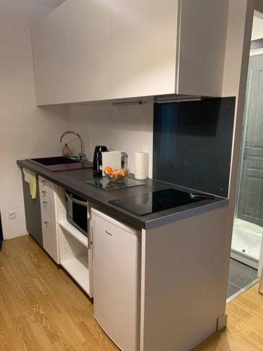 une cuisine avec un comptoir noir dans une pièce dans l'établissement Studio à Noyarey avec wifi, à Noyarey