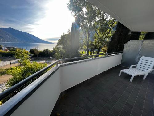 a balcony with a bench and a view of the water at Hotel Oasi Wellness & Spa in Riva del Garda
