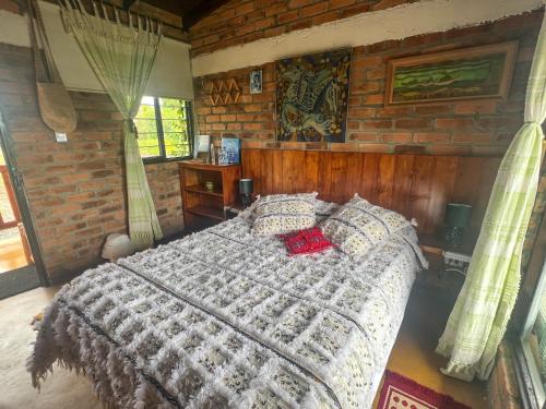 a bedroom with a bed in a brick wall at Campground Hostal La Bonanza Chez Kika in Piendamó