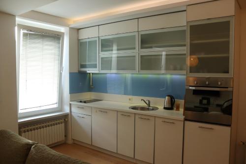 a kitchen with white cabinets and a sink at Moonlight Shadow Apartment in Sarajevo