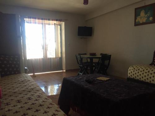 Schlafzimmer mit einem Bett, einem Tisch und einem Fenster in der Unterkunft Villa Said in Moulay Bousselham