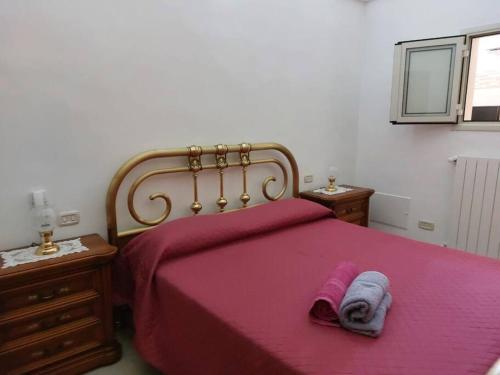 ein Schlafzimmer mit einem Bett mit einer roten Decke und zwei Nachttischen in der Unterkunft Locazione turistica messapi in Manduria